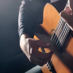 Acoustic guitar player. Classical guitarist hands playing music instrument closeup